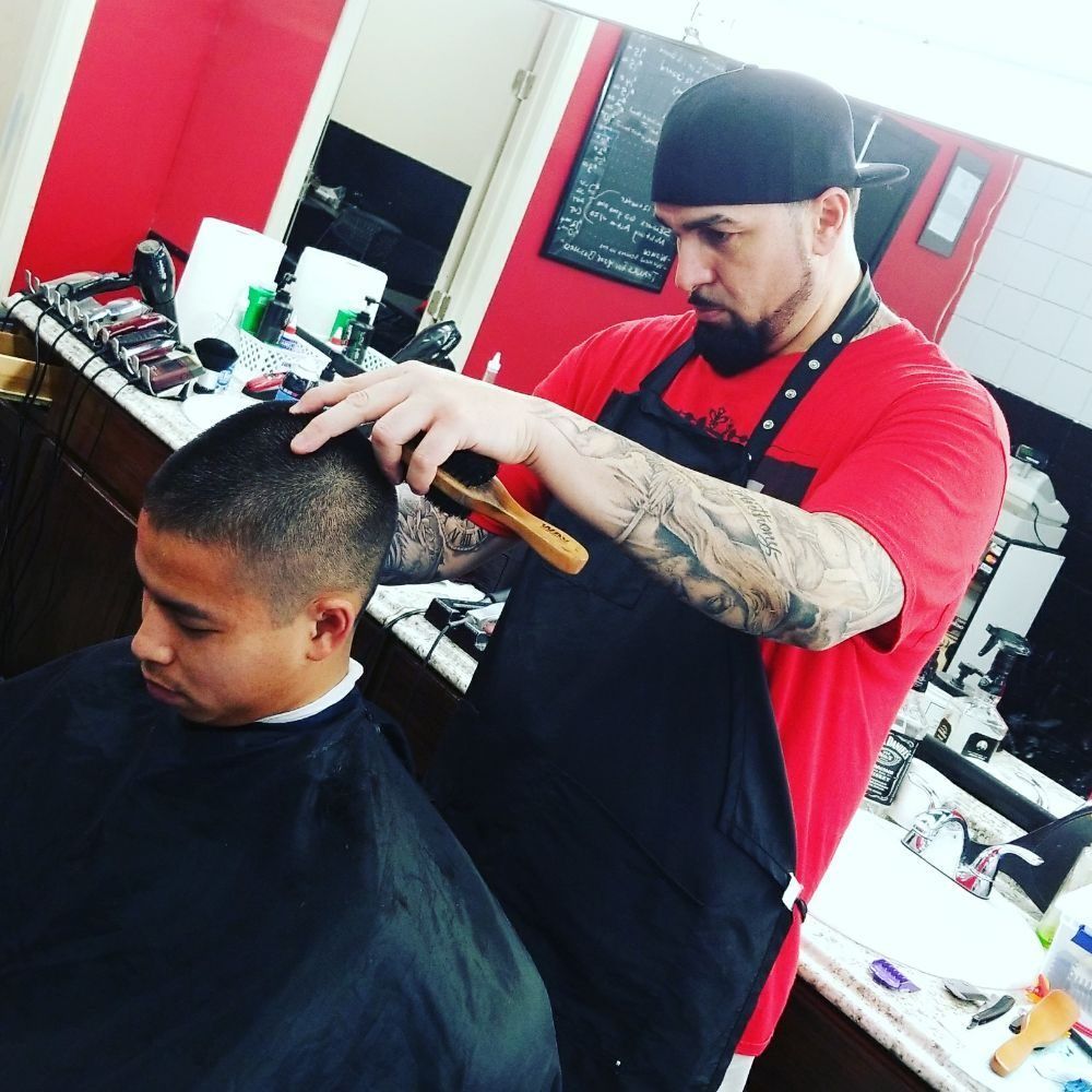 A man is getting his hair cut by a barber