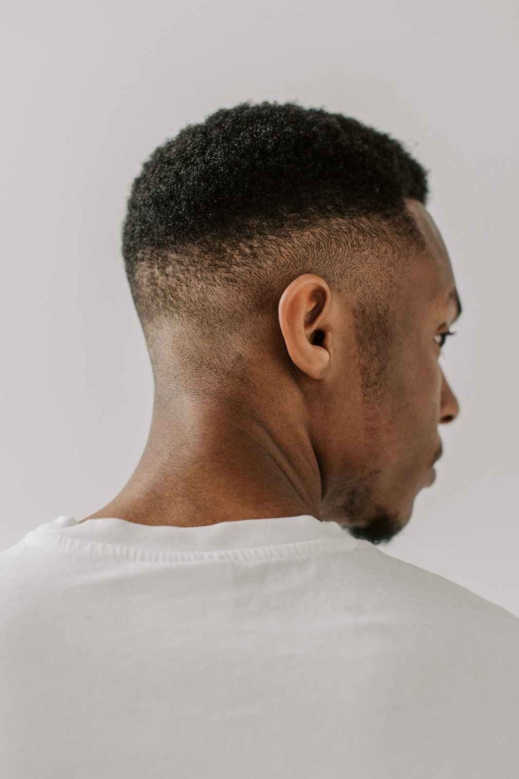 The back of a man 's head with a fade haircut.