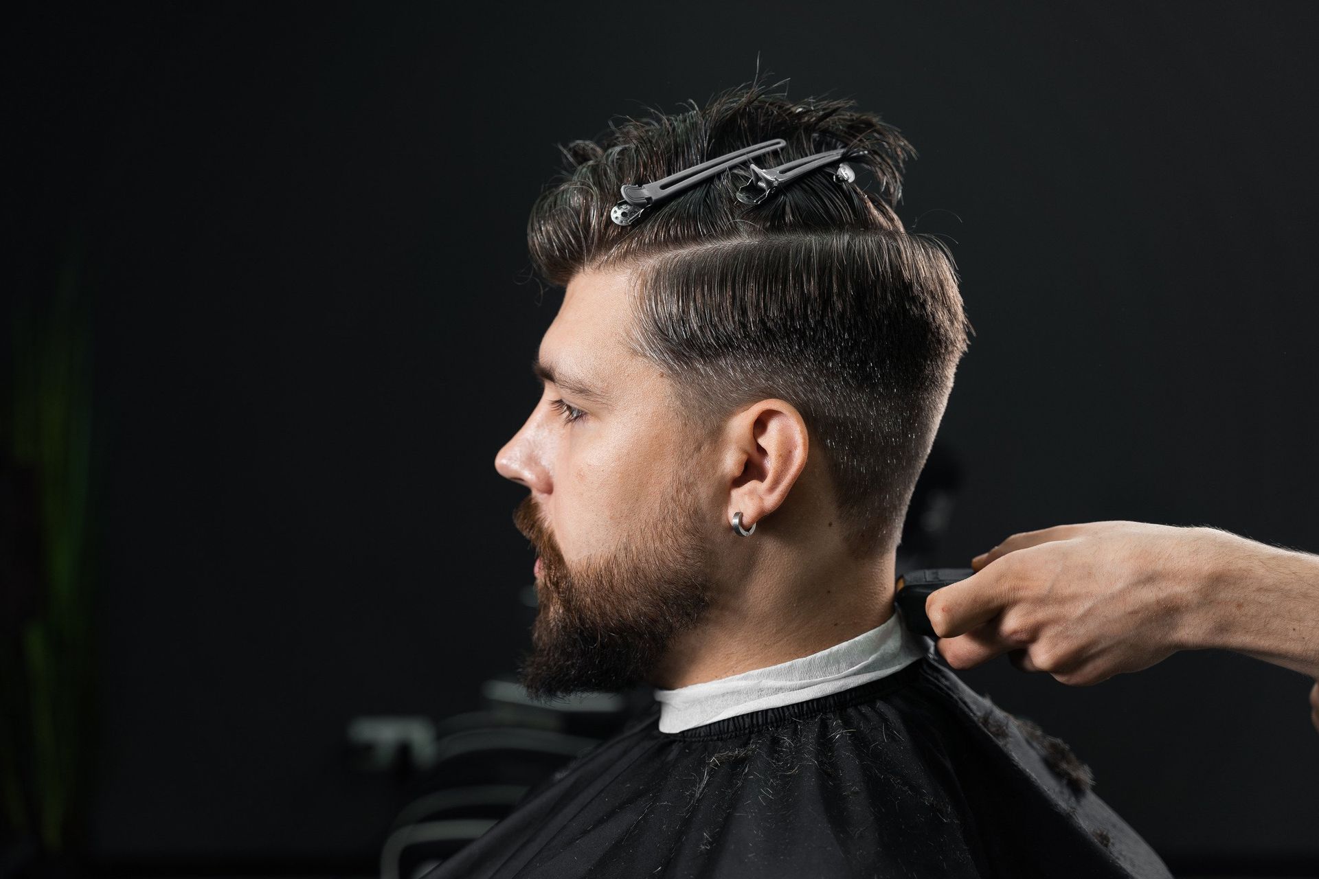 A man is getting his hair cut by a barber in a barber shop.