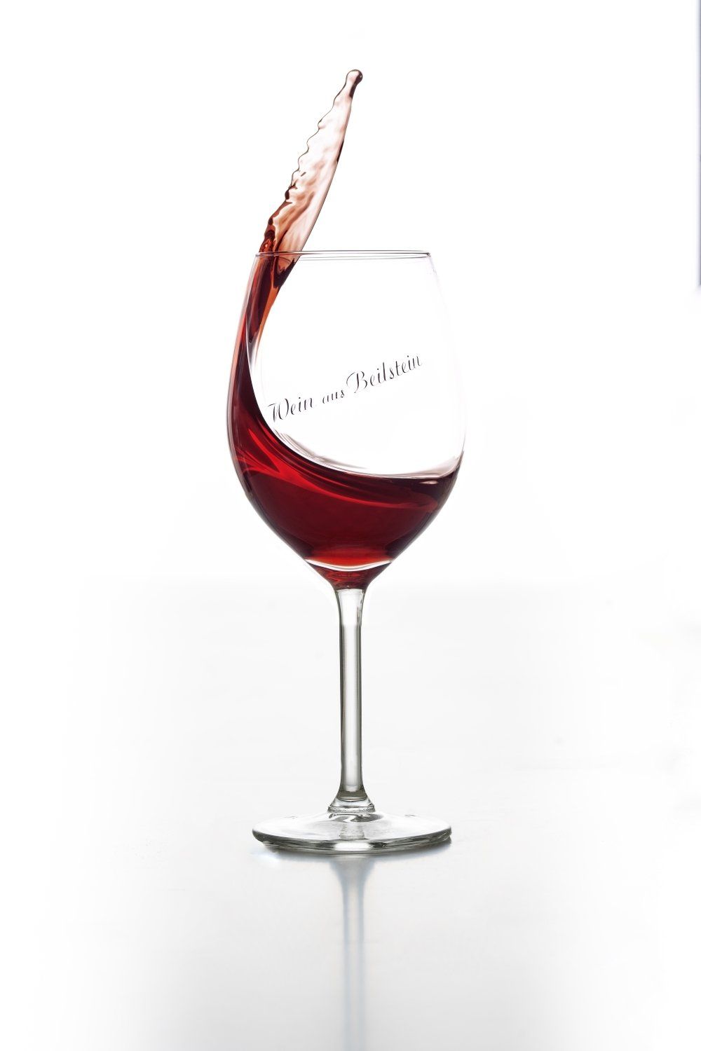 Ein Weinglas mit einem Schuss Rotwein darin