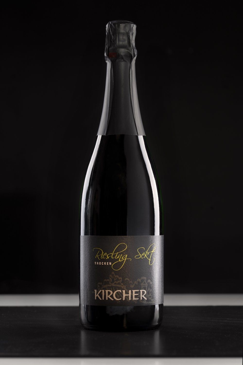 Auf einem Tisch steht eine Flasche Kircher-Champagner.