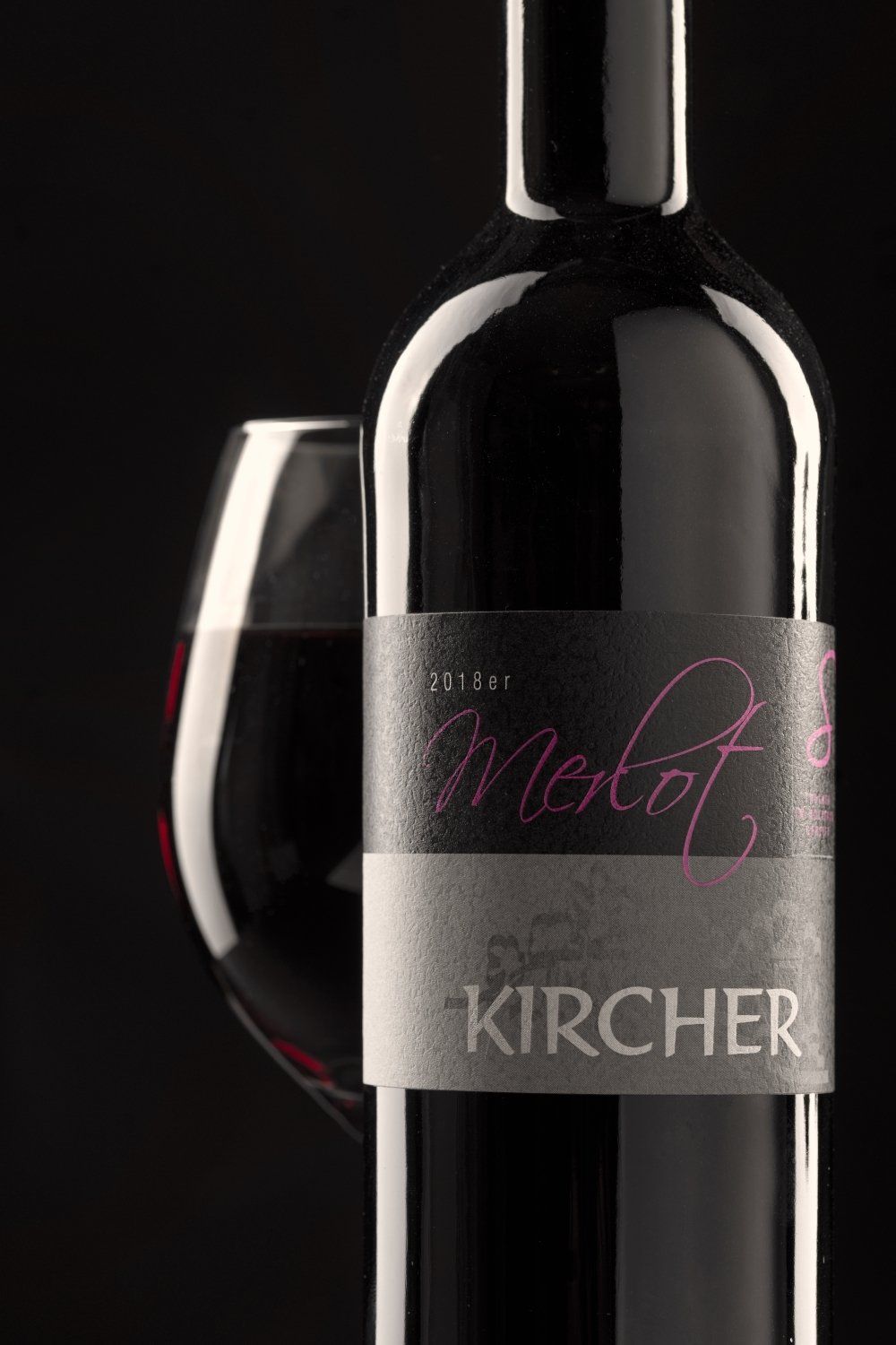 Eine Flasche Merlot-Wein neben einem Glas Wein.