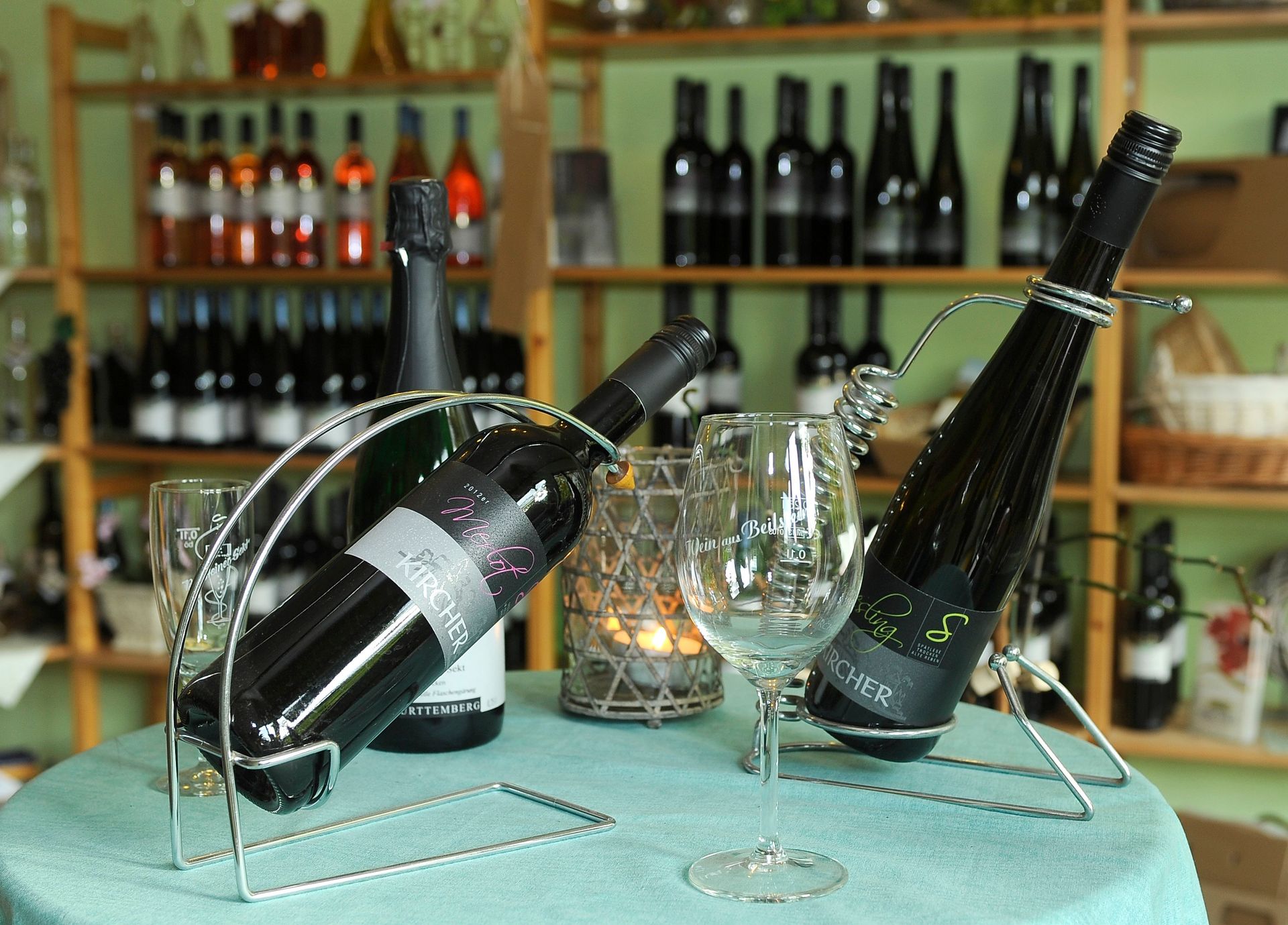 Zwei Flaschen Wein stehen neben Weingläsern auf einem Tisch.