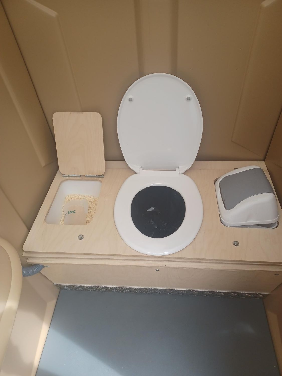 Toilettes portables beiges devant une cathédrale, à côté d'une balustrade en métal.