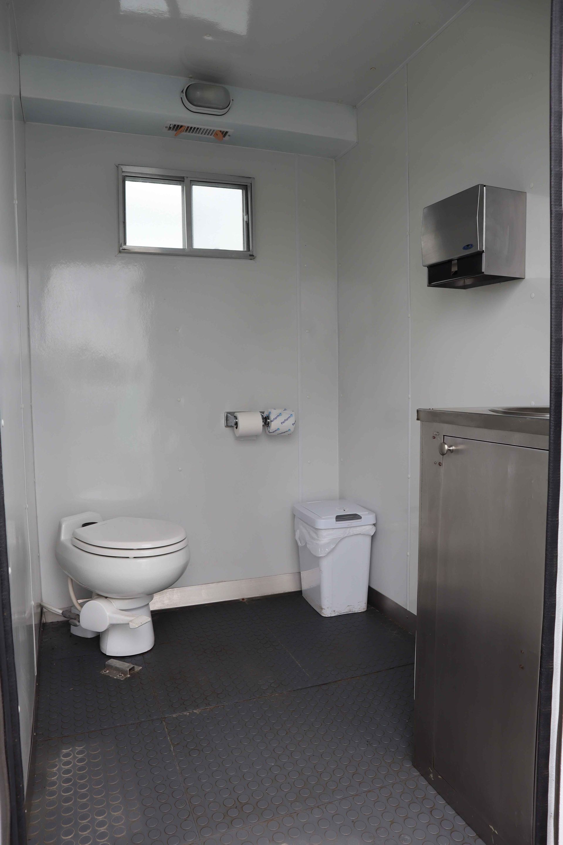 Remorque blanche à deux portes, stationnée sur l'asphalte; vue extérieure.