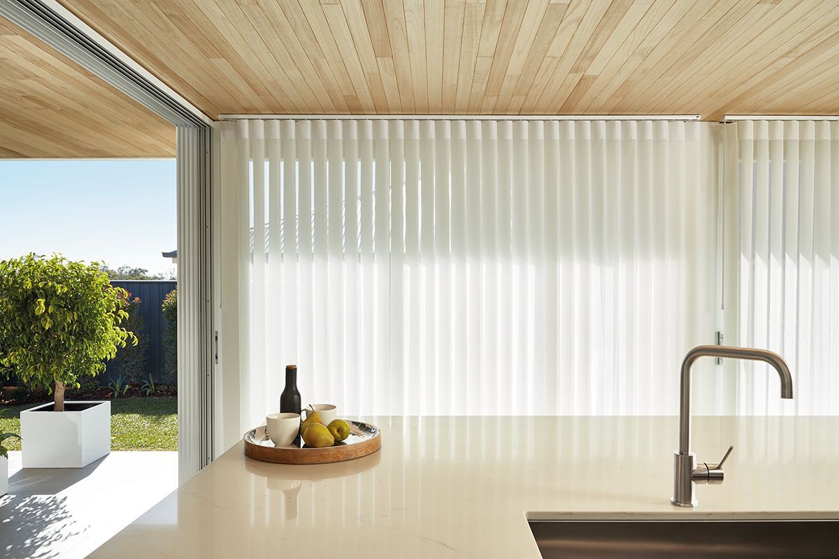 A kitchen with a sink and a bottle of wine on the counter.
