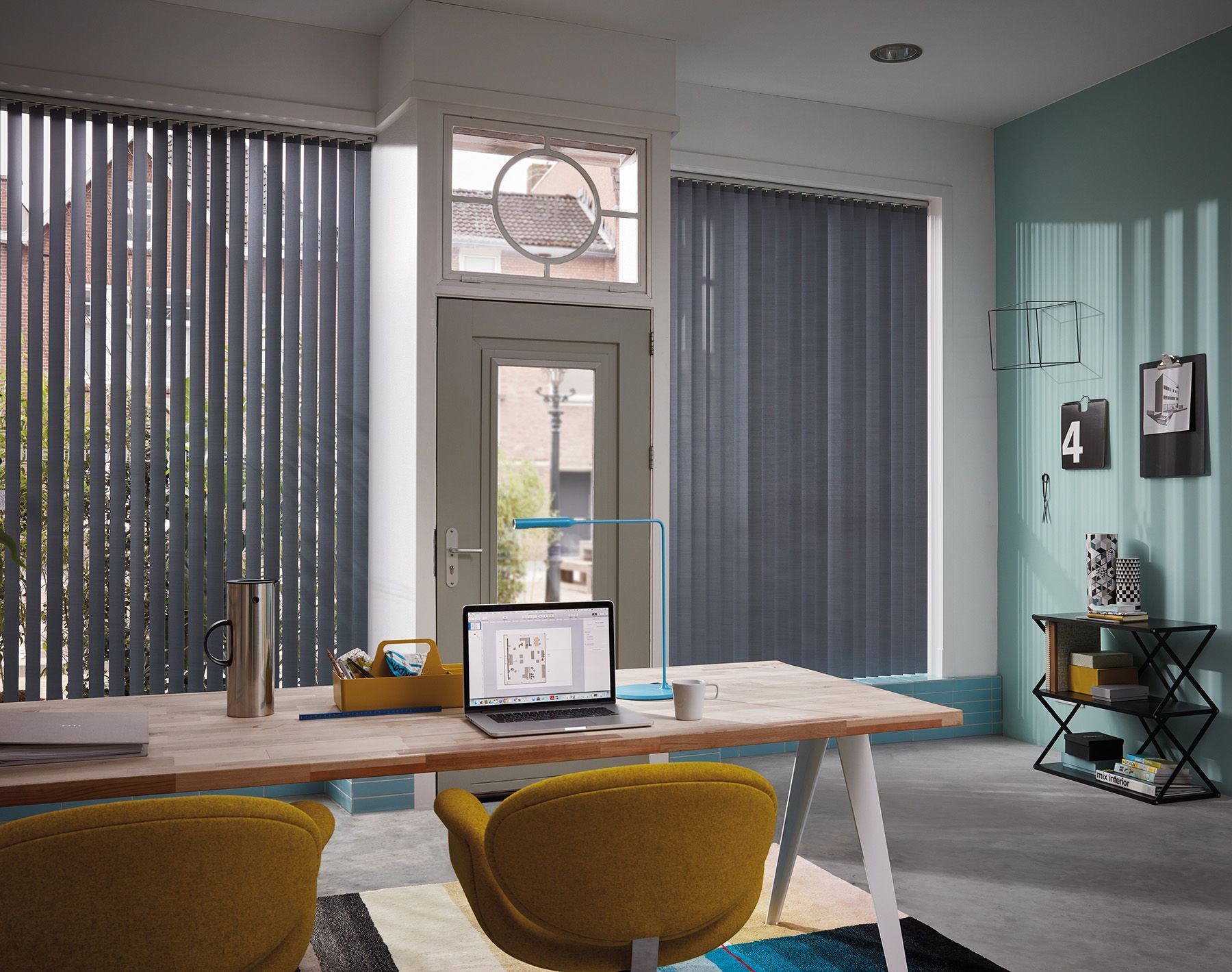 A room with a desk and chairs and a laptop on it