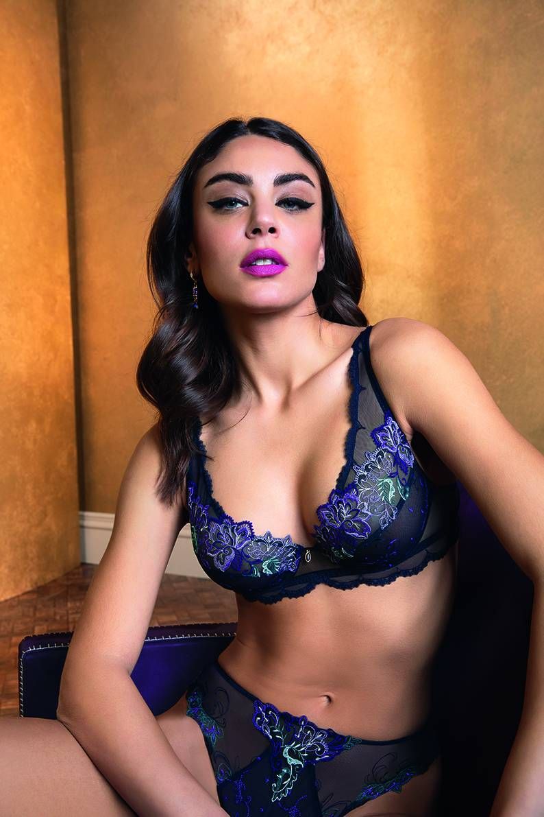 Une femme en lingerie est assise sur une chaise.