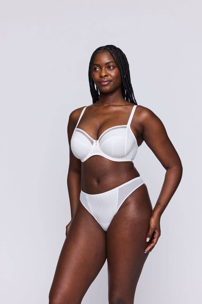 Une femme porte un soutien-gorge blanc et un string blanc.
