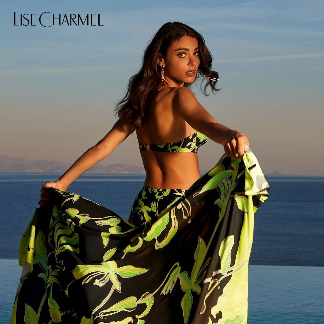 Une femme en bikini se tient à côté d'un plan d'eau