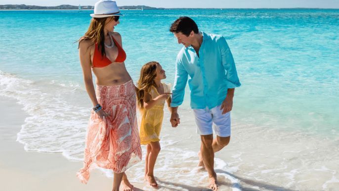 Family walking along a white sand beach