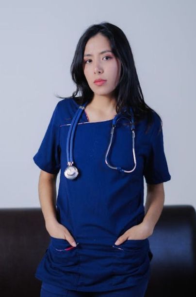 Una mujer que lleva una blusa azul y un estetoscopio alrededor del cuello.