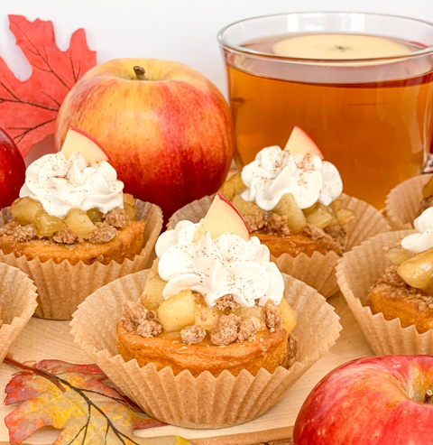 coffee cakes topped with apple pie filling and whipped cream placed on a fall background