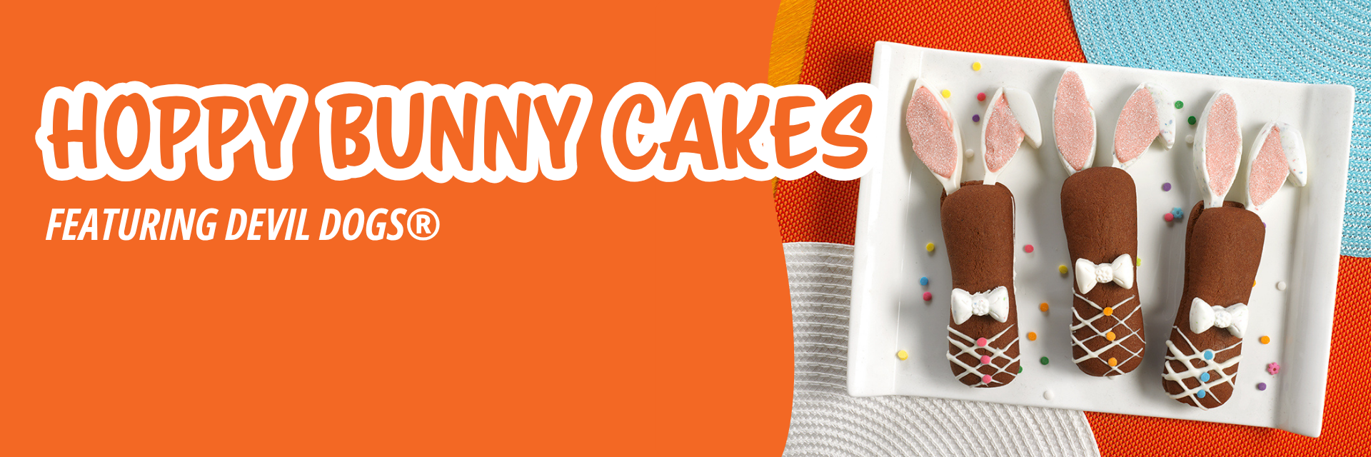 Orange banner promoting three brown chocolate-coated treats decorated as Easter bunnies with marshmallow ears and icing ties on a white plate.