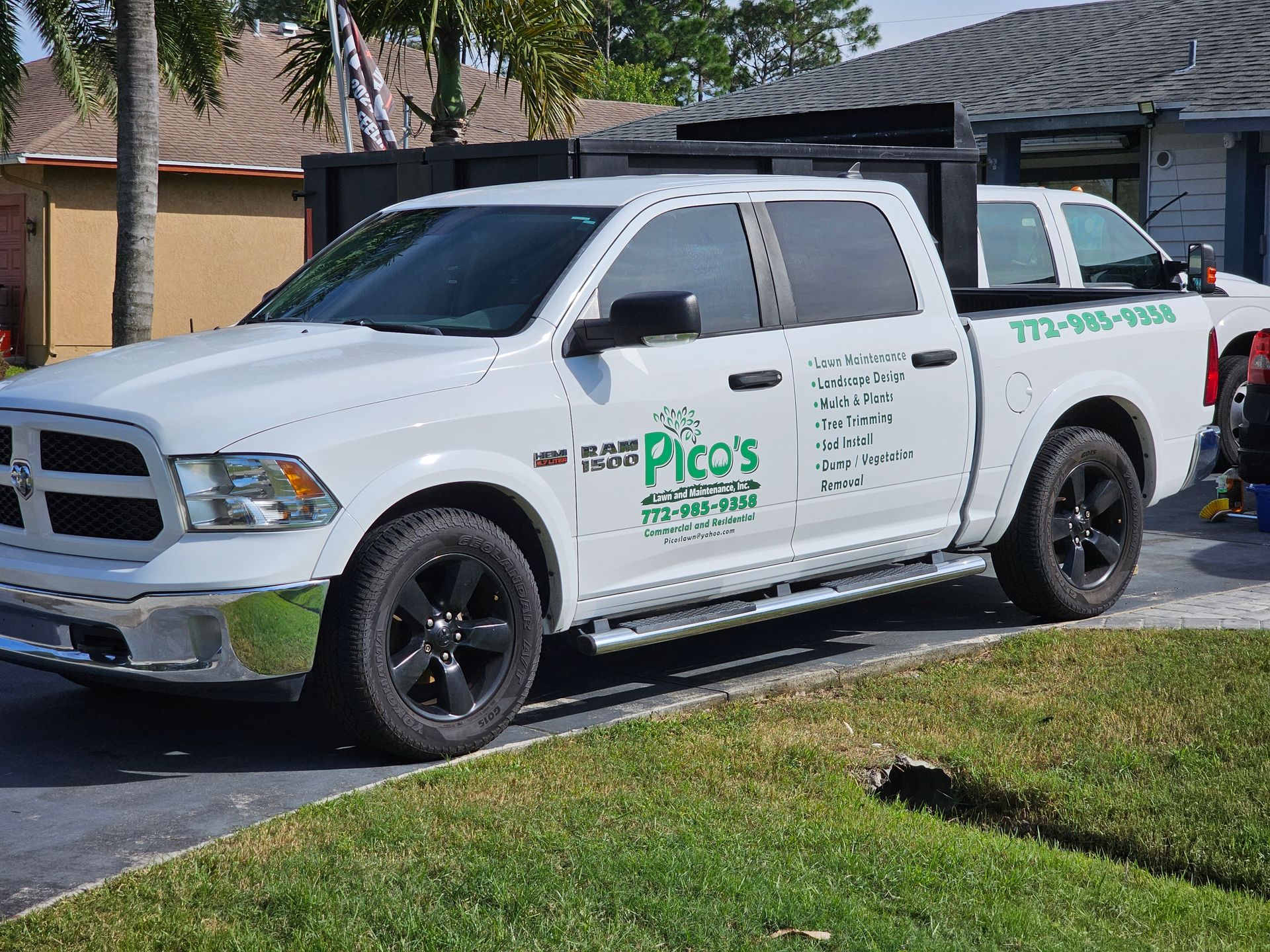 A white dodge ram truck is parked in the driveway of a house.