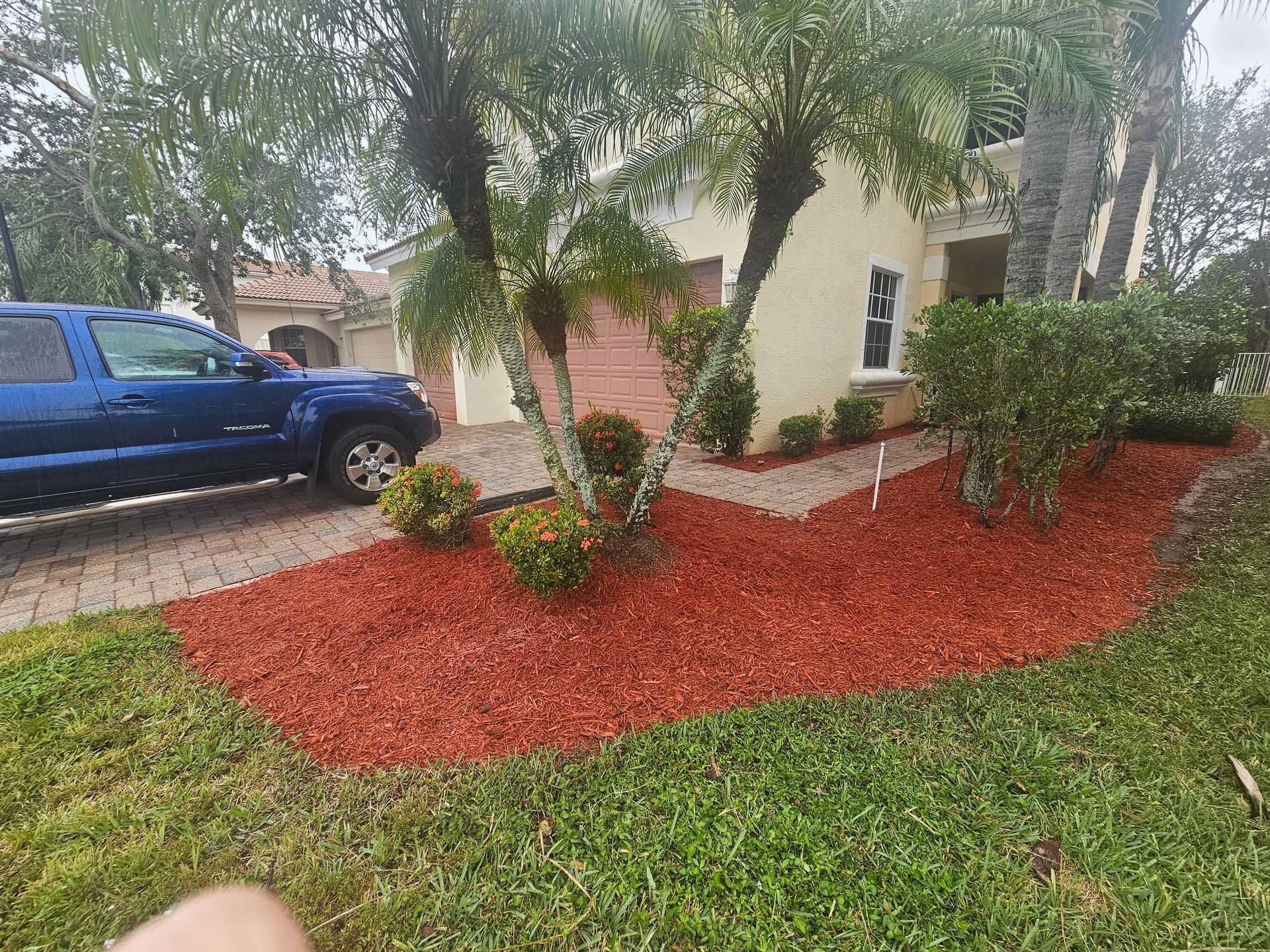 A blue truck is parked in front of a house.