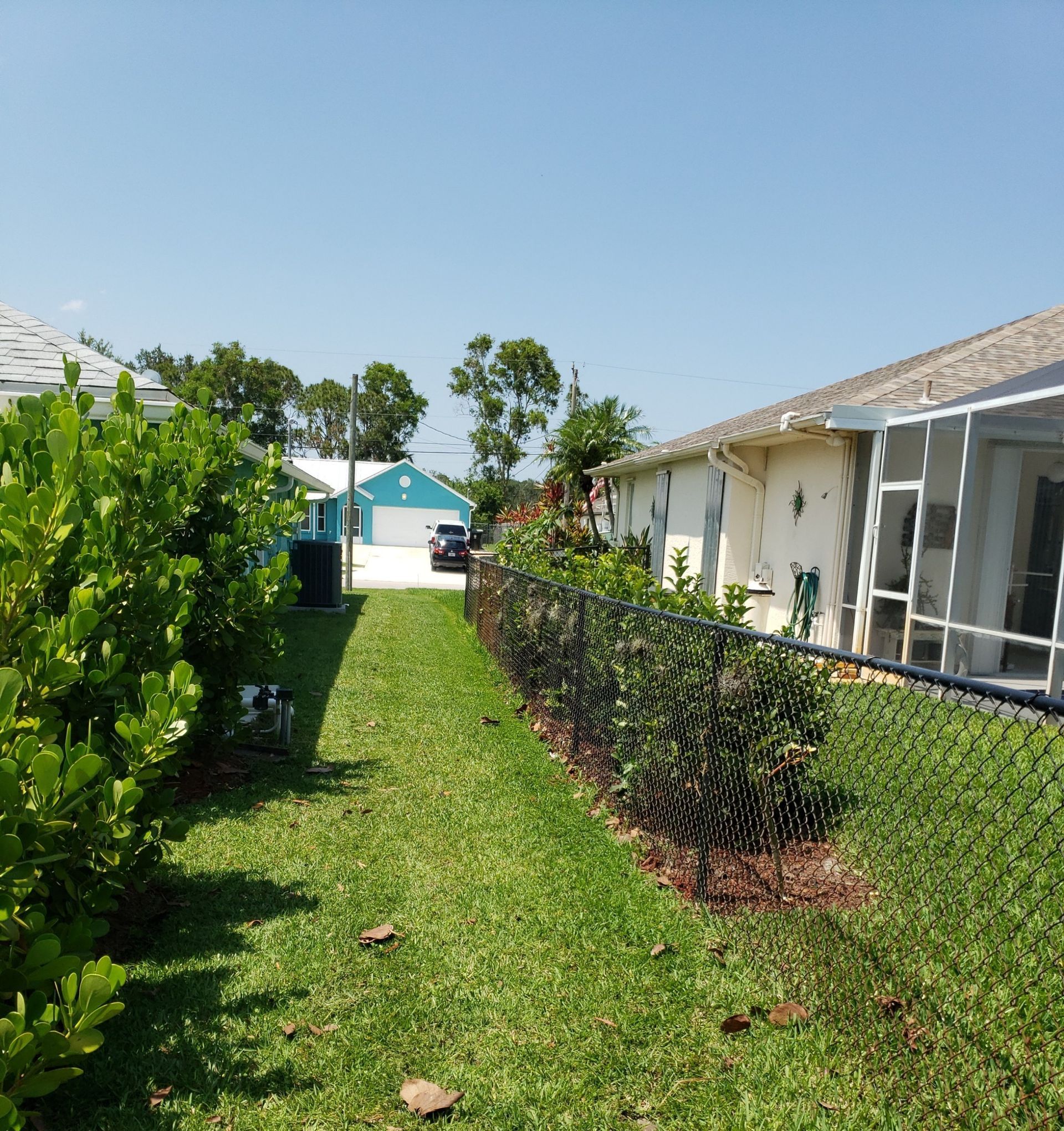 A fenced in yard with a house in the background