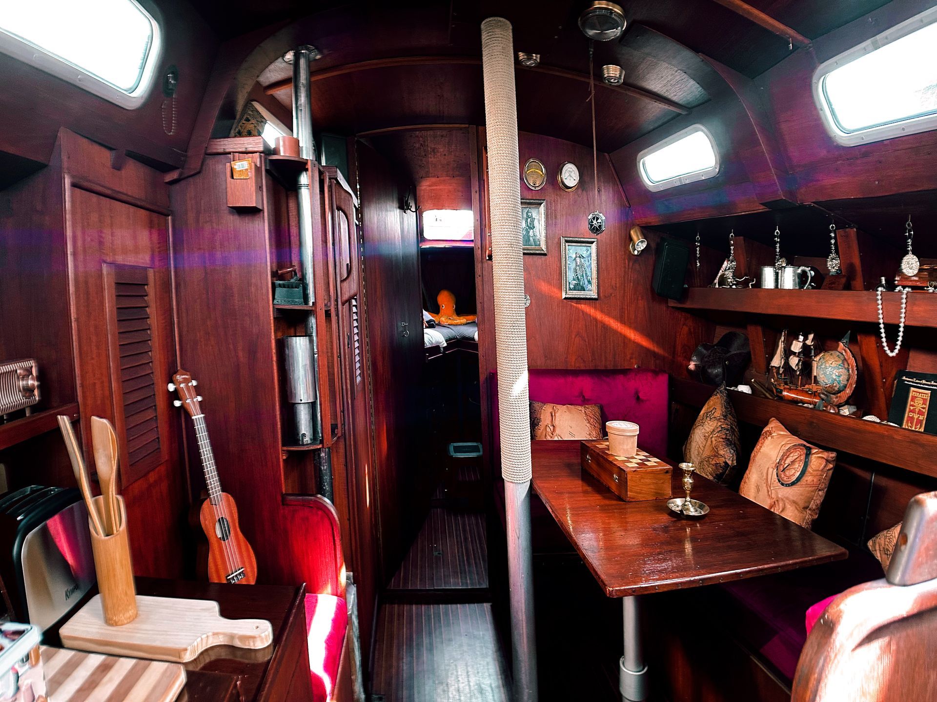 The inside of a boat with a table and chairs.