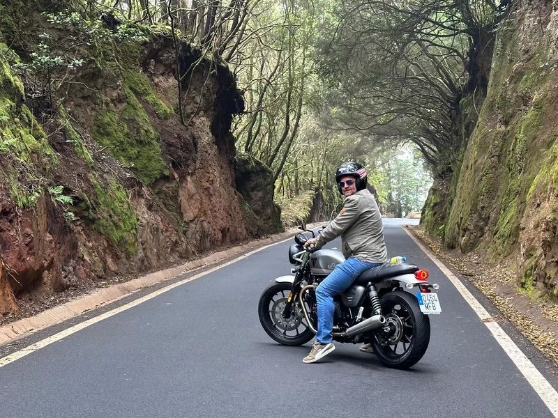 A man is riding a motorcycle down a road.