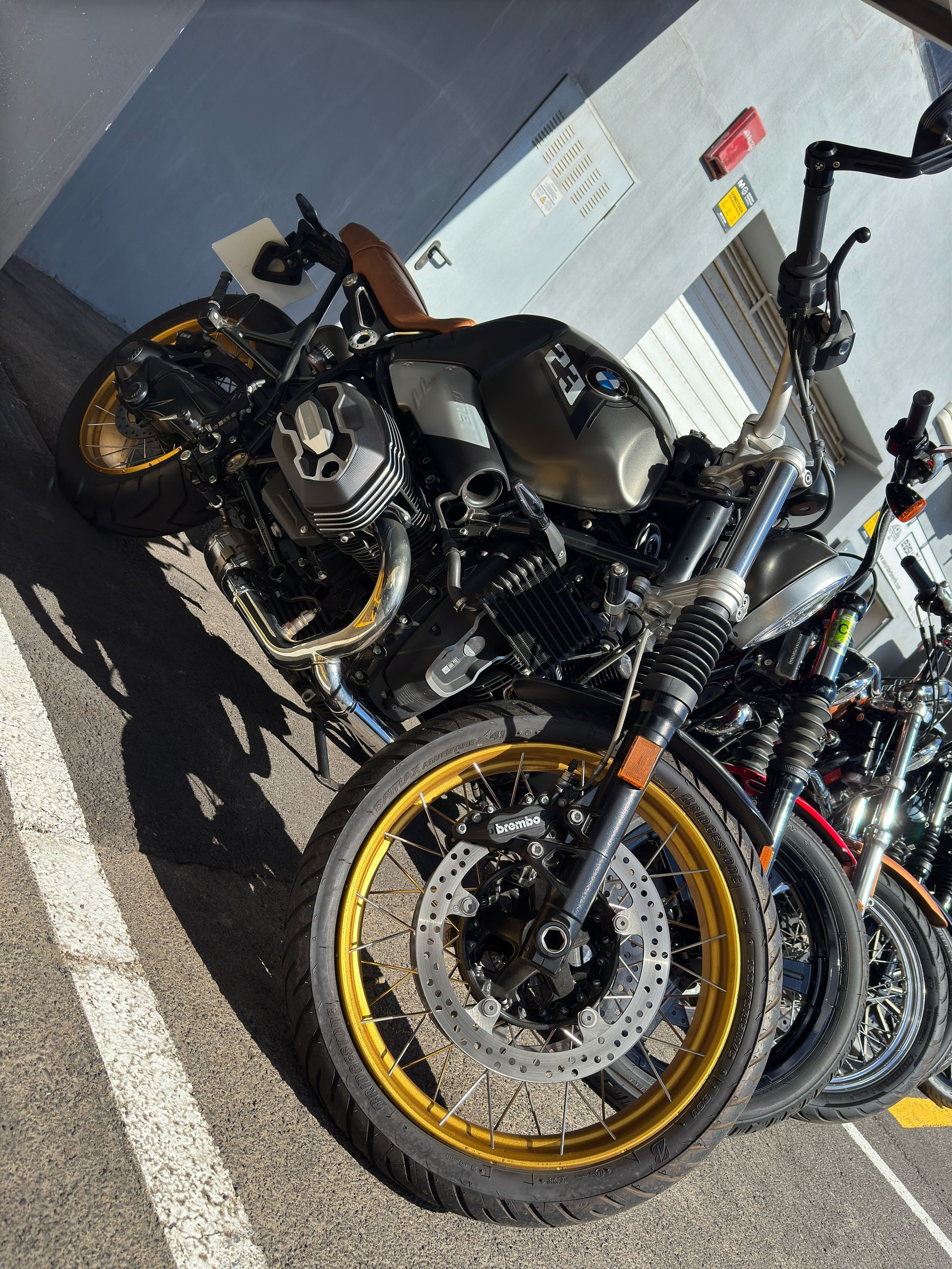 A row of motorcycles are parked next to each other in a parking lot.