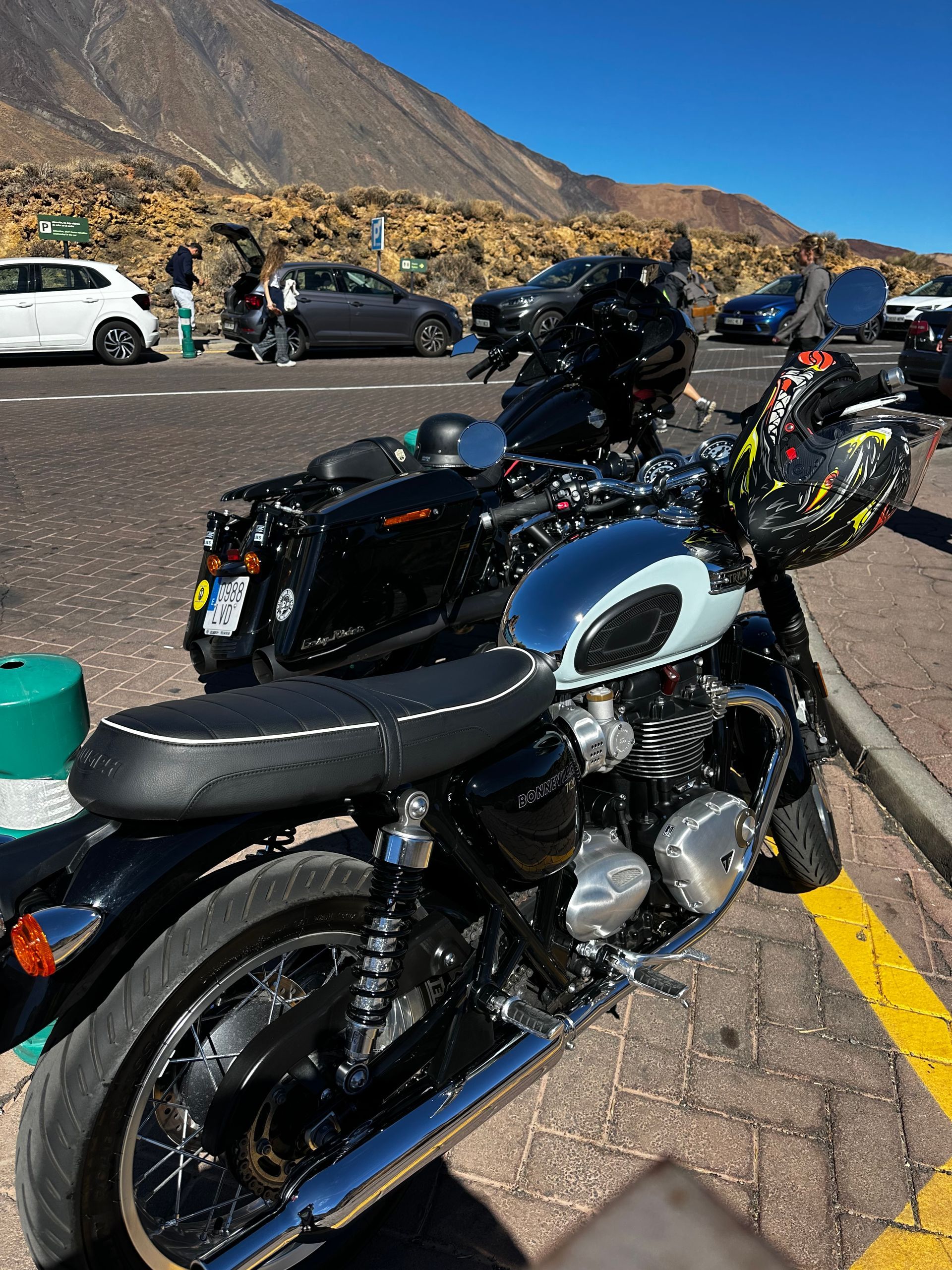 A row of motorcycles are parked in a parking lot.