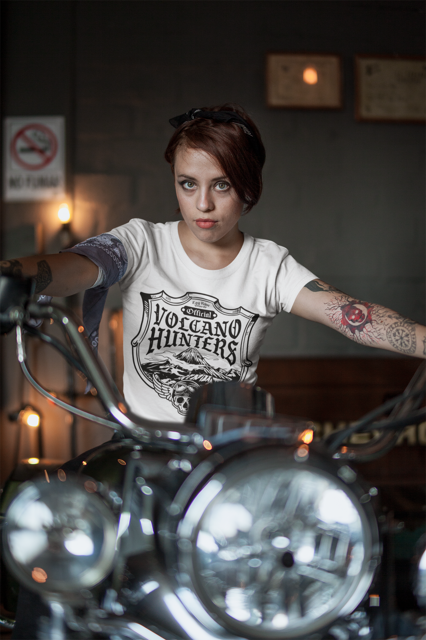 A woman is standing next to a motorcycle in a room.