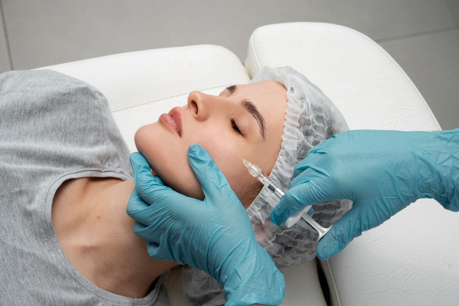 A woman is getting a botox injection in her face.