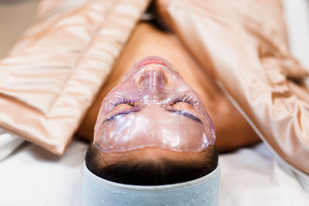 A woman is laying on a bed with a mask on her face.