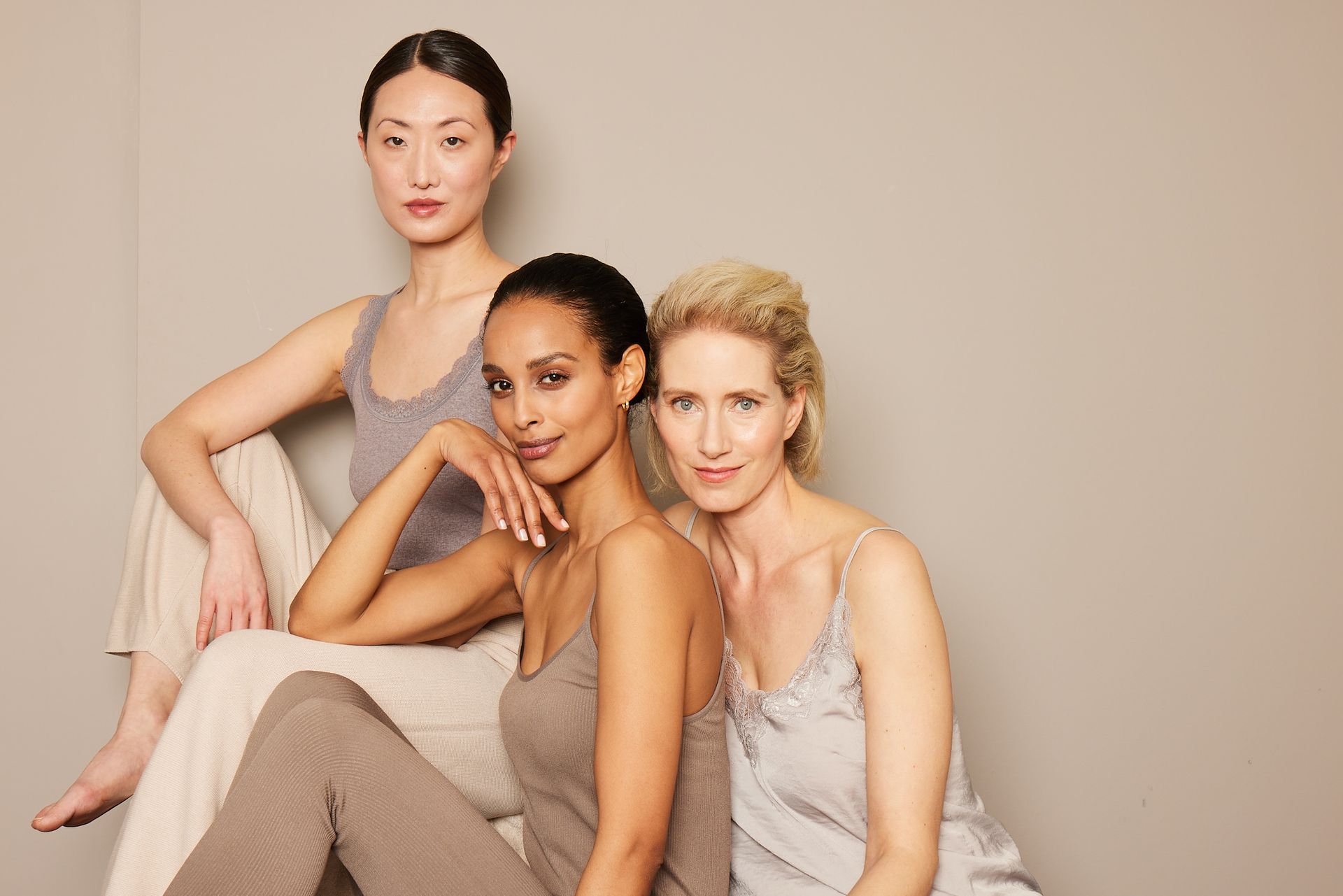Three women of different races are posing for a picture together.