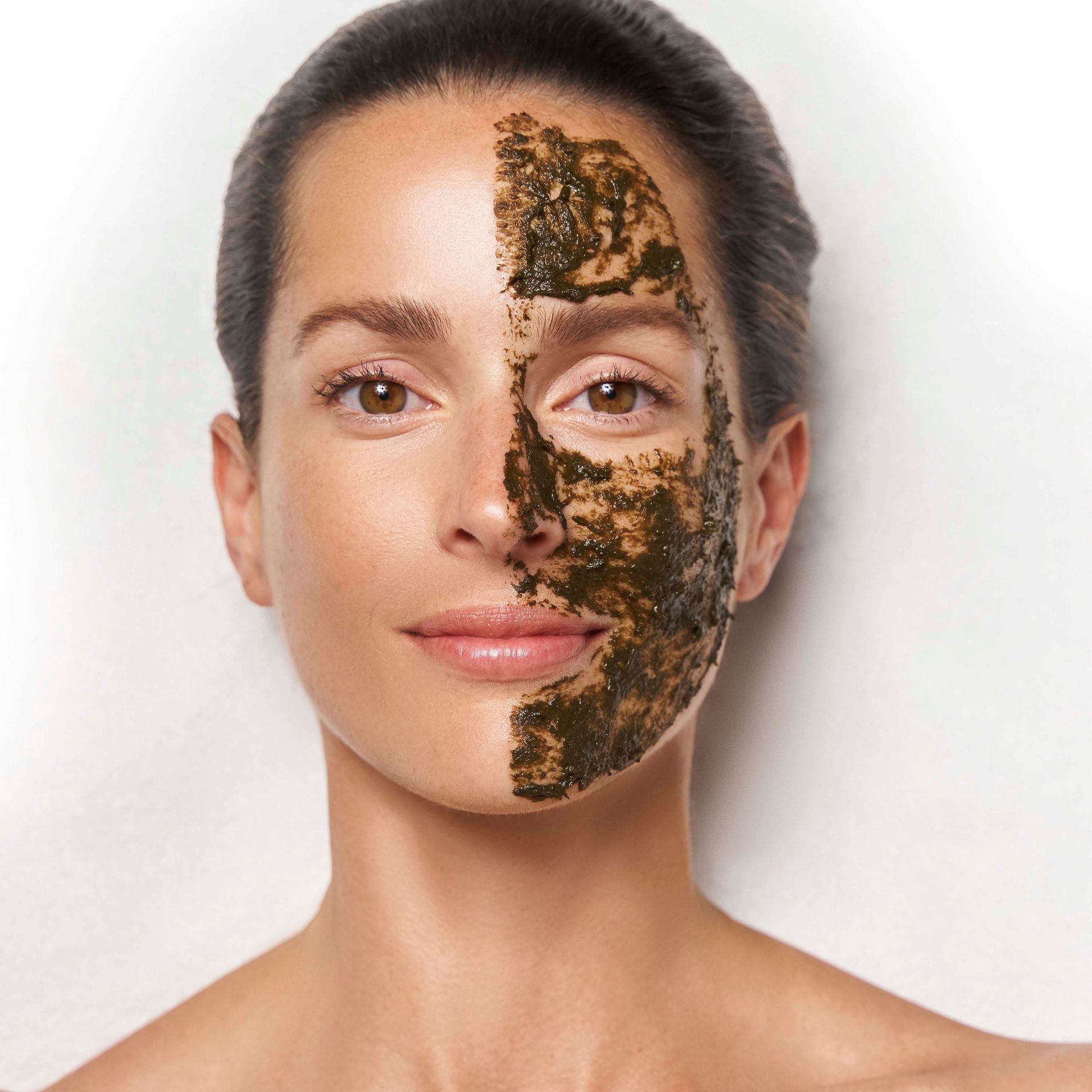 A woman is peeling off a plastic mask from her face.