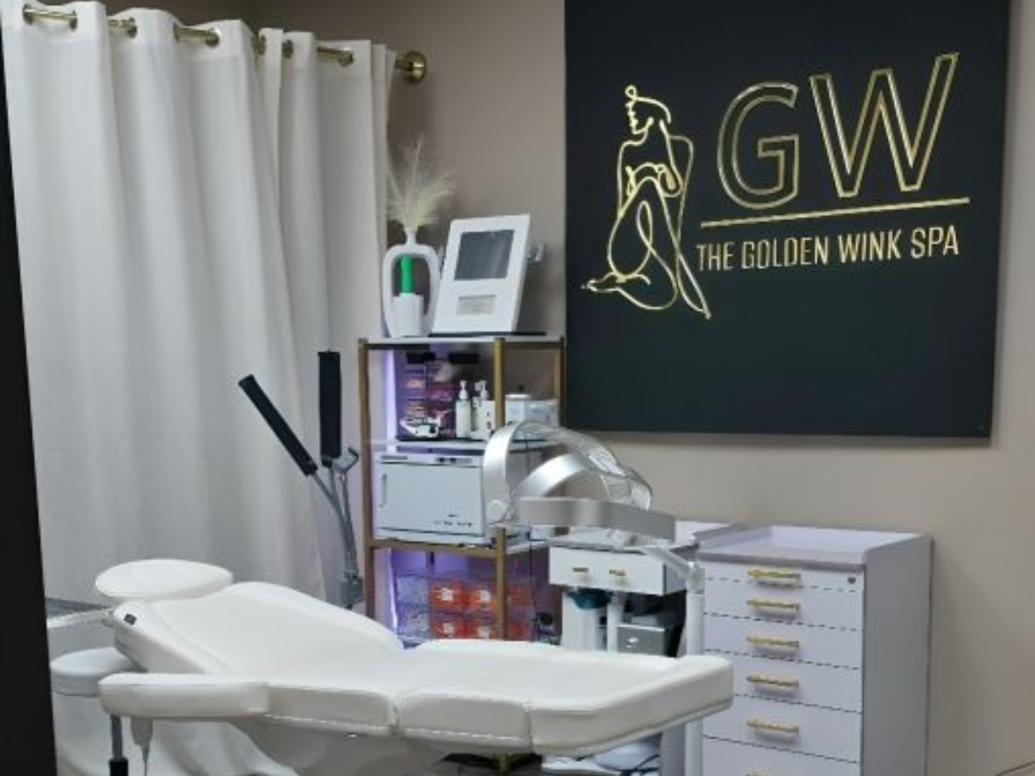 Serene treatment room at The Golden Wink Spa with warm, gold accents and a relaxing atmosphere