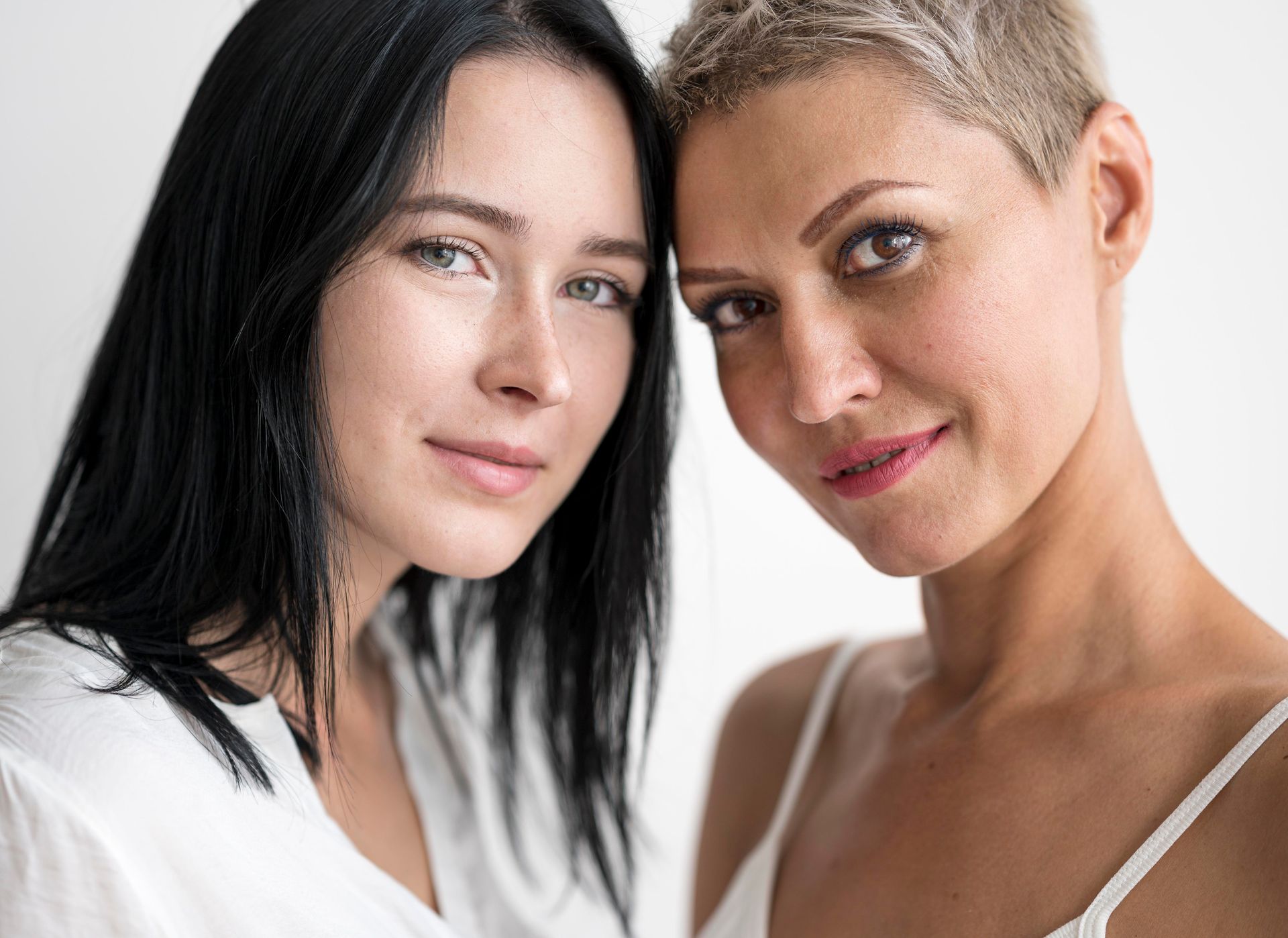 Two women are standing next to each other and smiling for the camera.