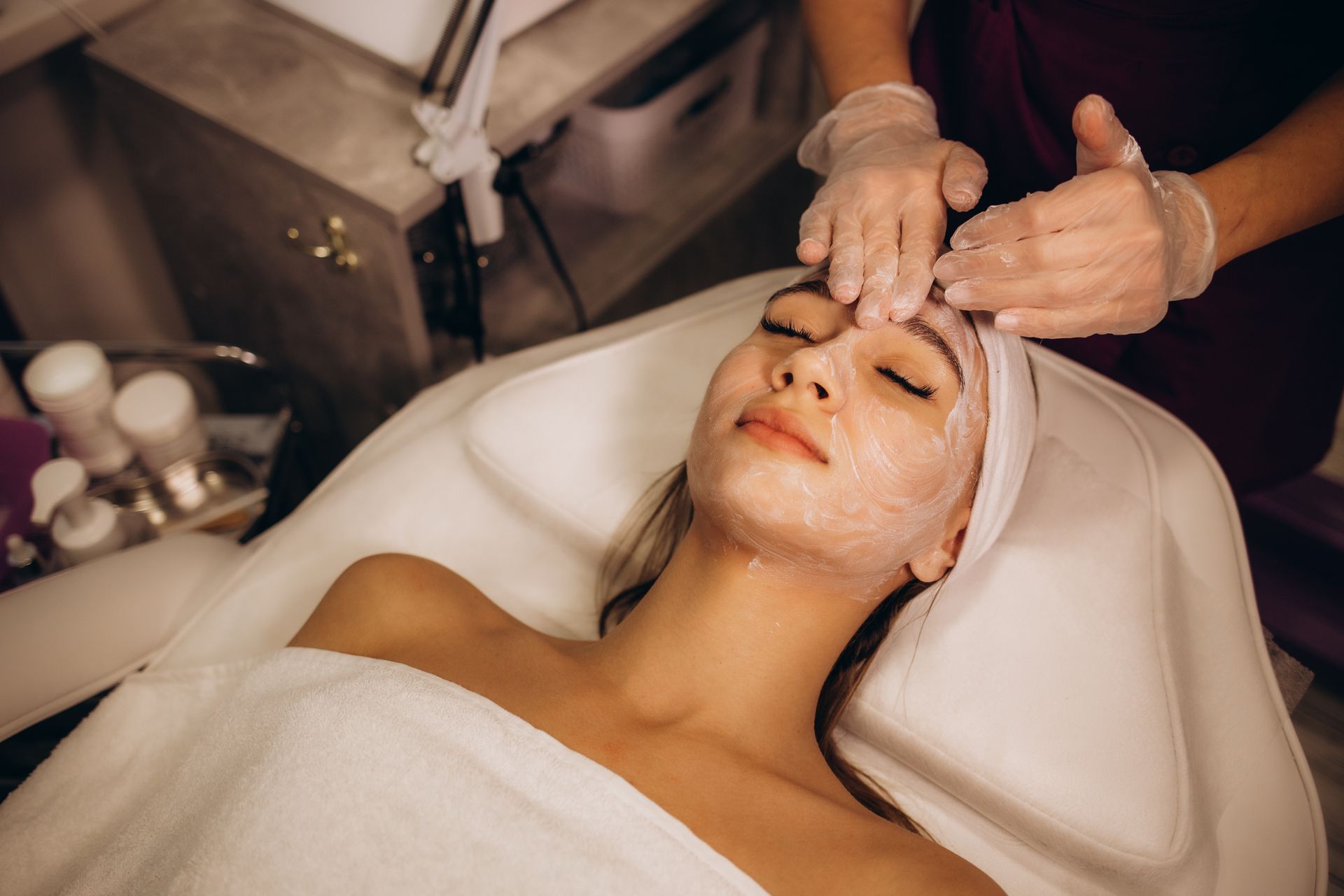 A woman is getting a facial treatment in a spa.