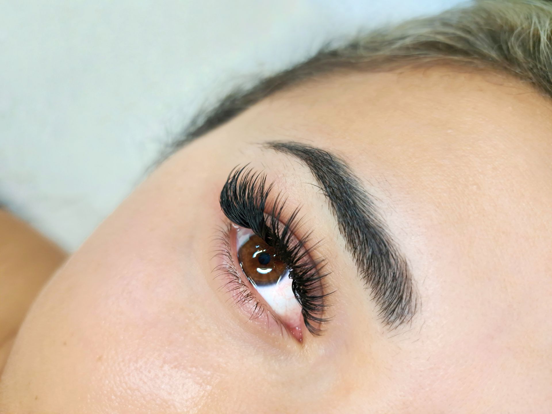 A close up of a woman 's eye with long eyelashes.