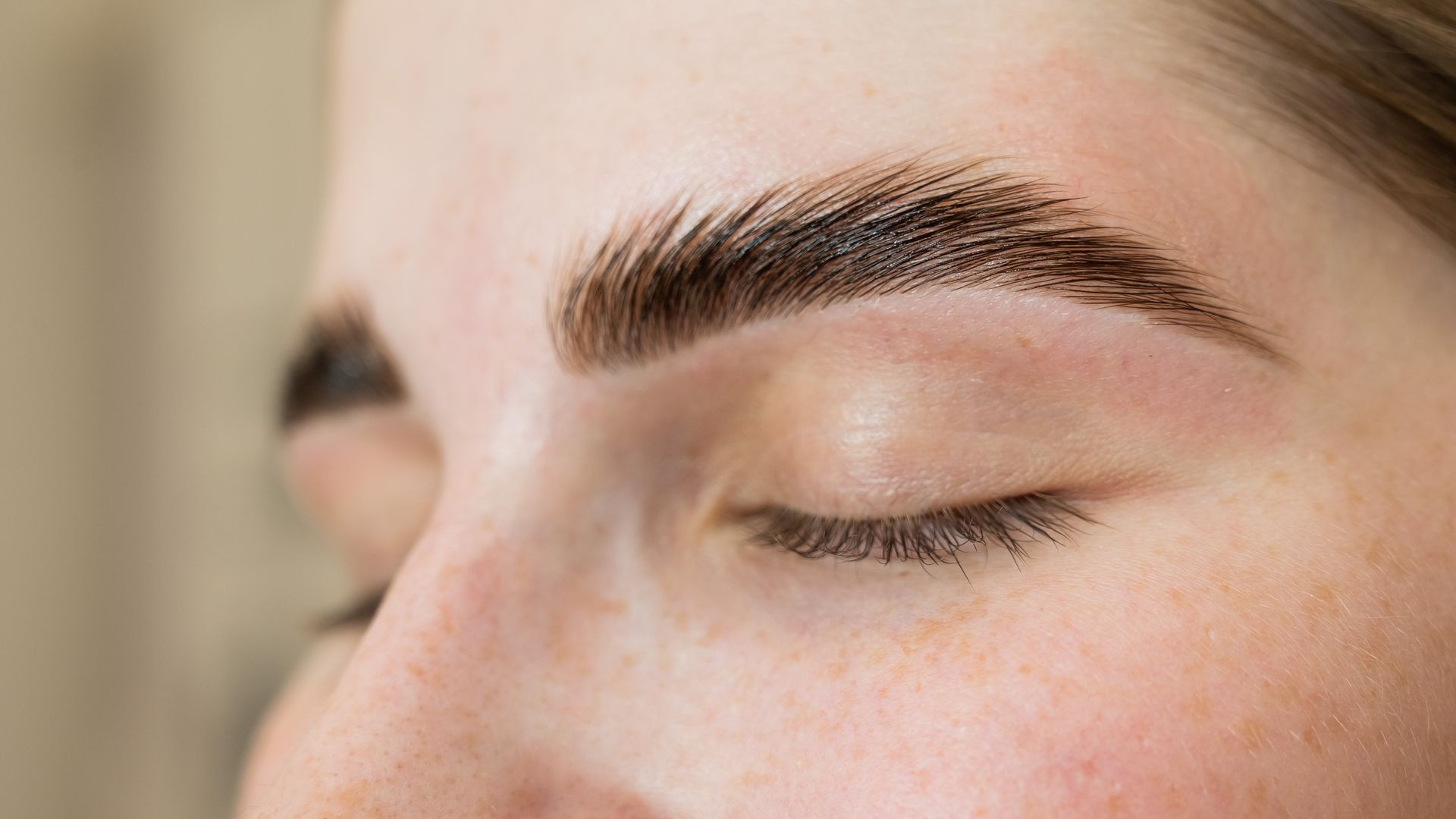 A close up of a woman 's eyebrows with her eyes closed.