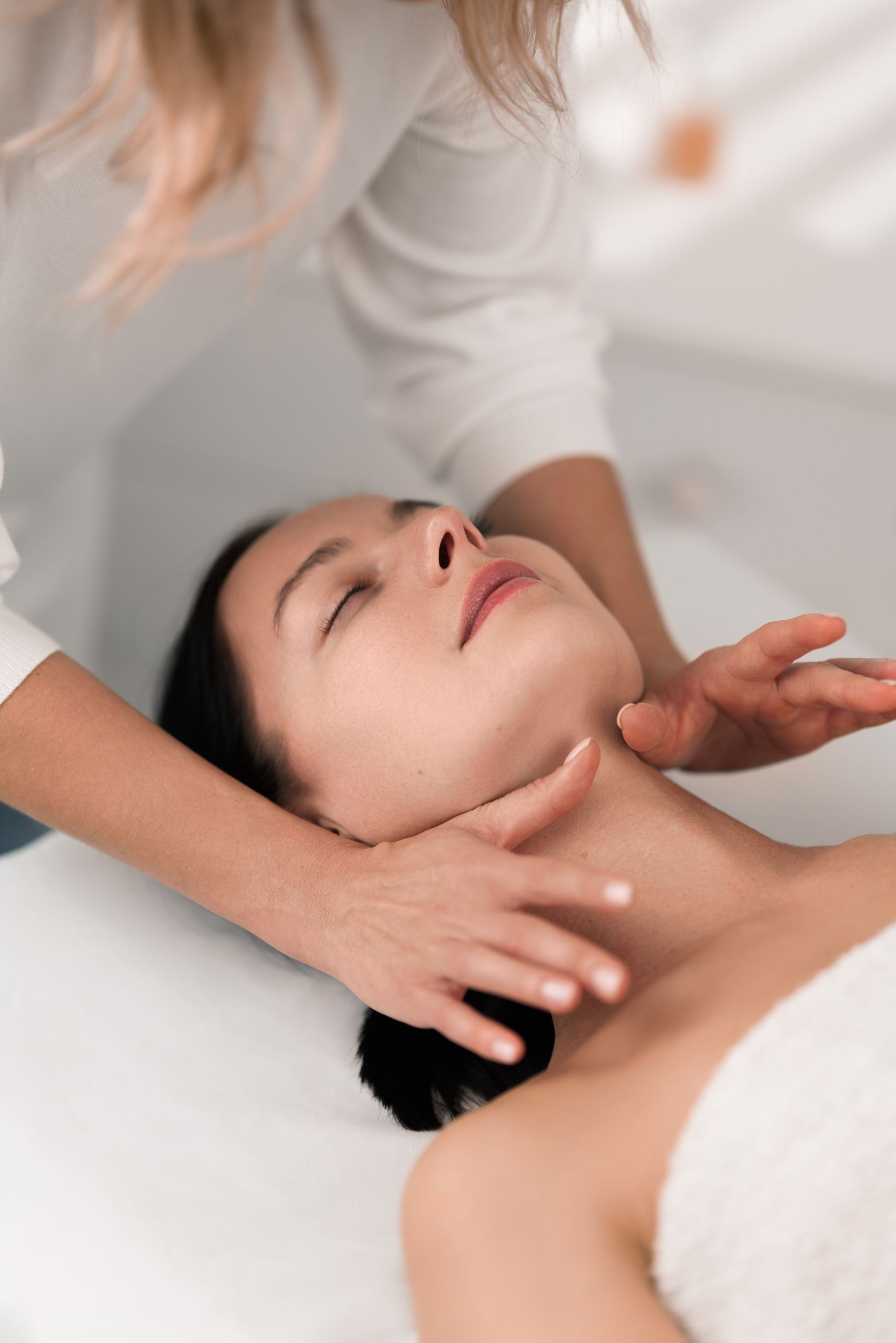 A woman is getting a massage on her neck in a spa.
