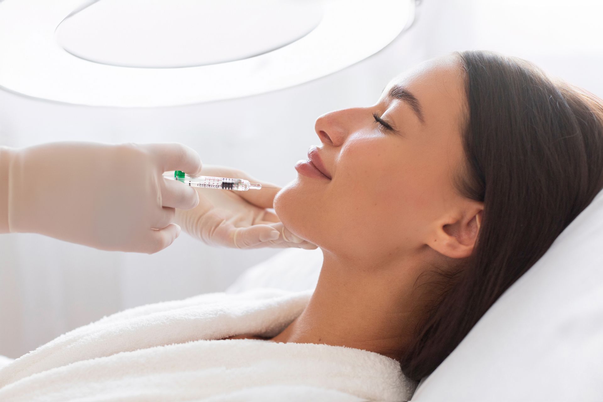 A woman is getting a botox injection in her face.