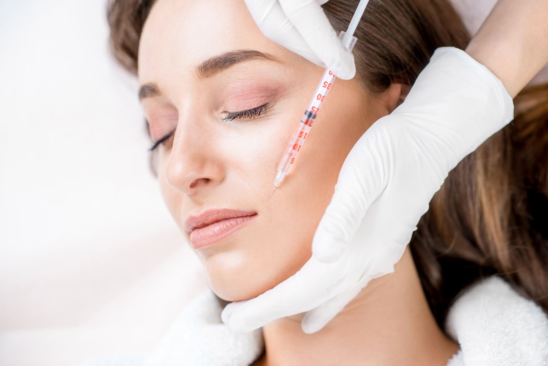 A woman is getting a botox injection in her face.