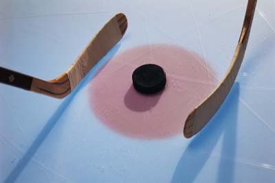 Puck between two Hockey Sticks — Team Uniforms in Philadelphia, PA