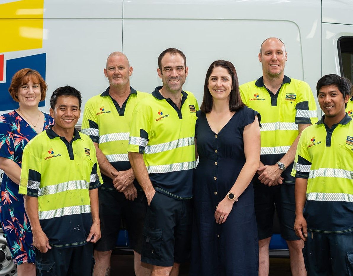 A Group of People Are Posing for a Picture in Front of a Van — Trusty Glass In Alice Springs, NT