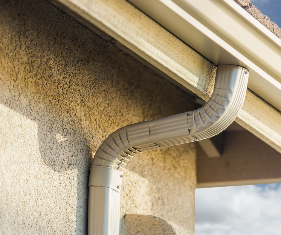 A close up of a gutter on the side of a house.