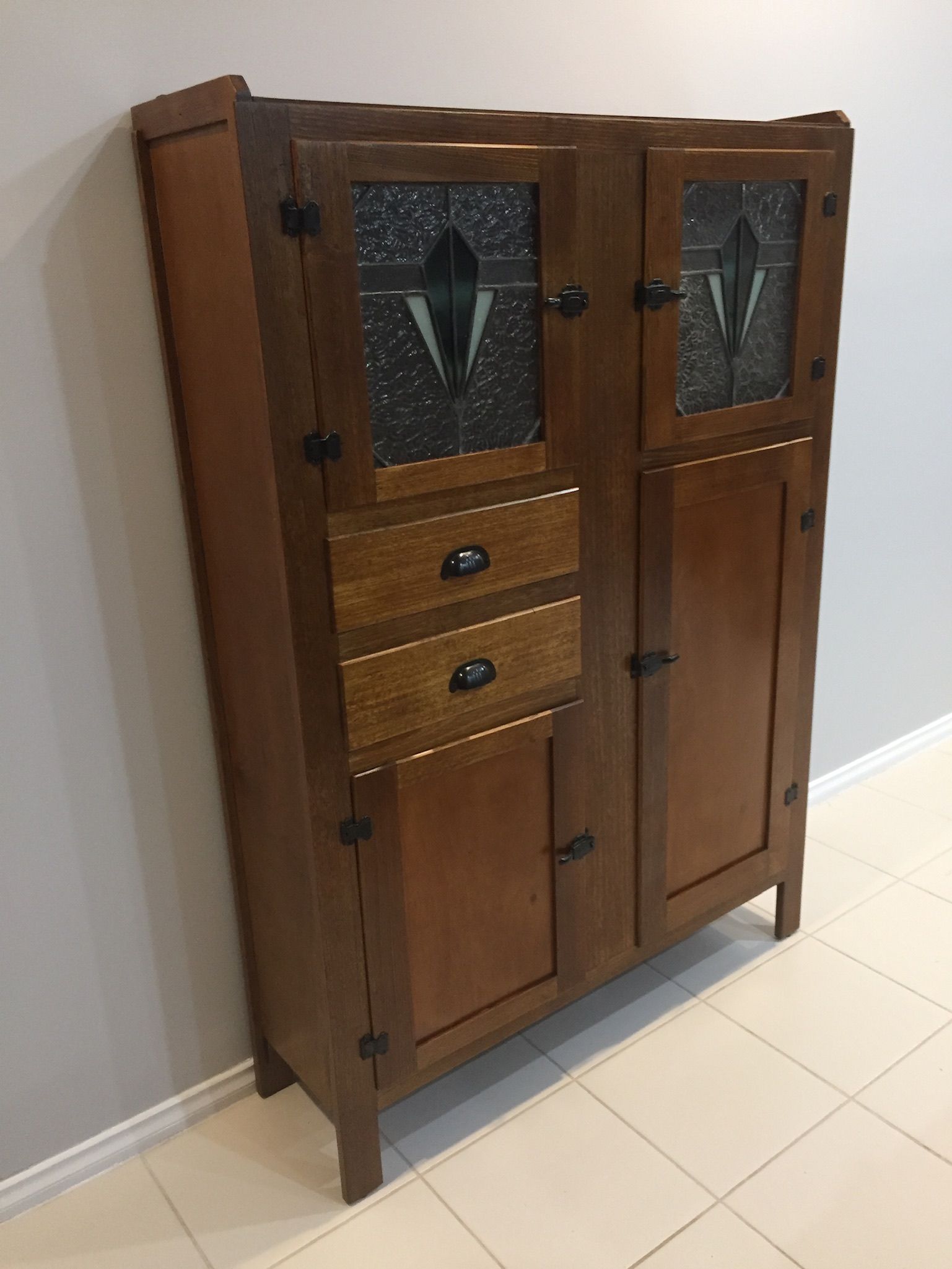 A Wooden Cabinet With Drawers And Glass Doors Is Sitting On A Tiled Floor — Envisage Furniture in Kialla, VIC