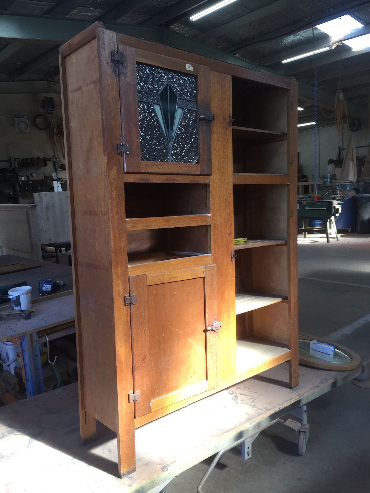 A Wooden Cabinet Is Sitting On Top Of A Wooden Table In A Warehouse — Envisage Furniture in Kialla, VIC