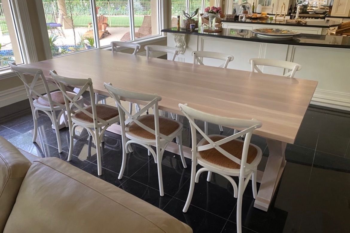 A Long Wooden Dining Table With White Chairs In A Living Room — Envisage Furniture in Kialla, VIC