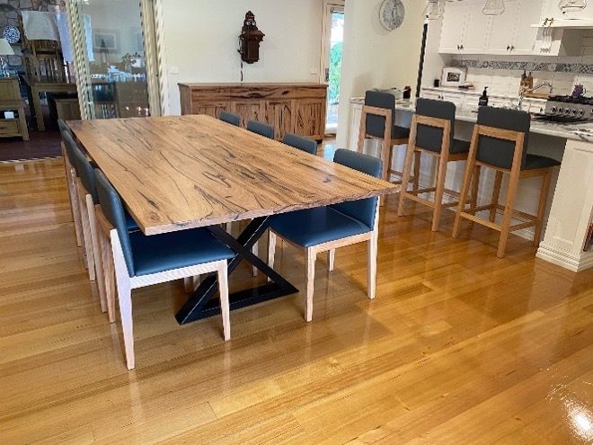A Wooden Dining Table With Blue Chairs In A Kitchen — Envisage Furniture in Kialla, VIC