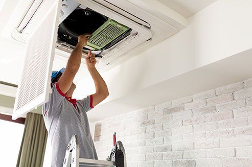 Worker Fixing Air Conditioner — Odessa, TX — Stephen's Plumbing Heating & Air Conditioning
