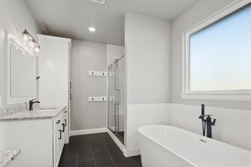 A bathroom with a tub , sink , mirror and walk in shower.