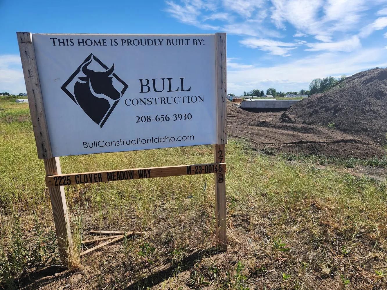 A bull construction sign is in the middle of a grassy field