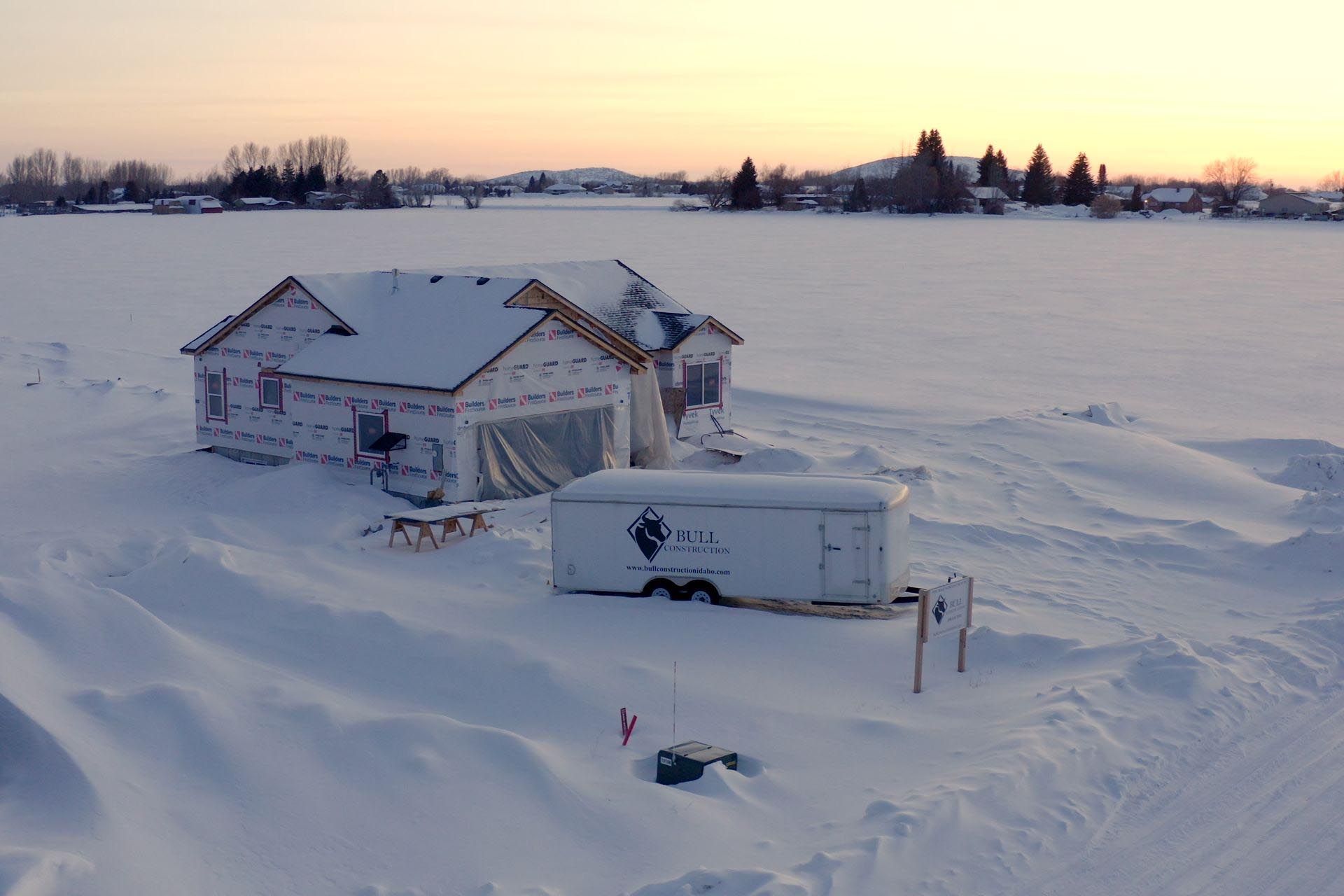 A house is being built in the middle of a snowy field