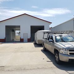 A truck is parked in front of a building with a trailer attached to it.